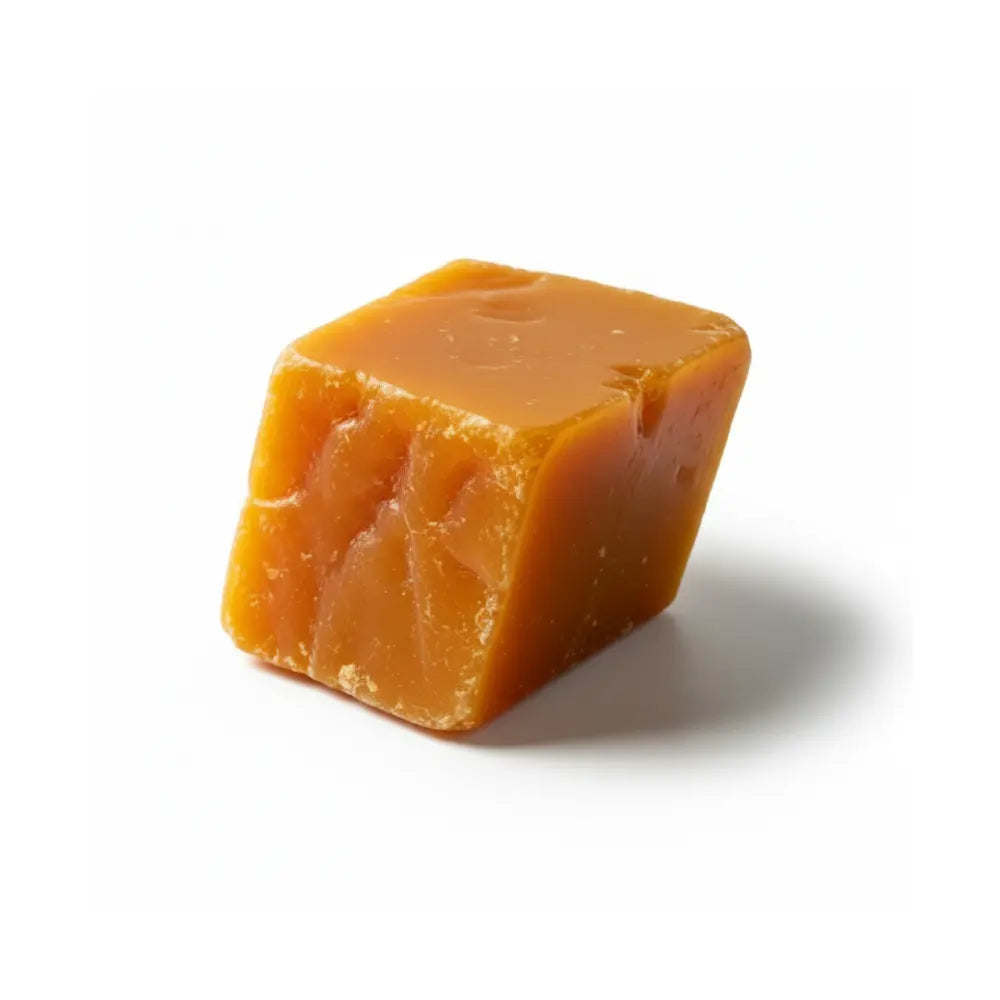 Block of amber-coloured carnauba wax on a white background