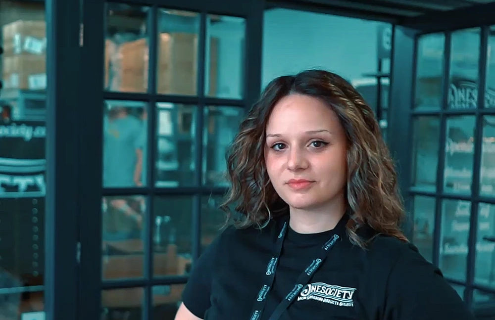 Person wearing a black one society shirt with visible branding in an indoor setting