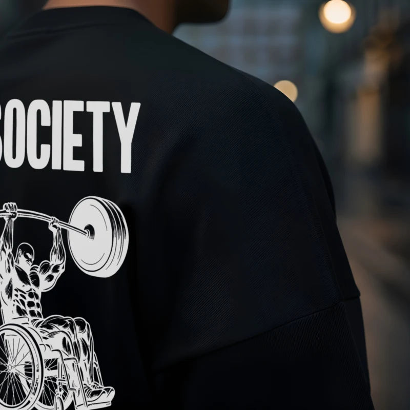 Black T shirt with a graphic design and 'SOCIETY' text on the back, featuring a person in a wheelchair lifting weights.