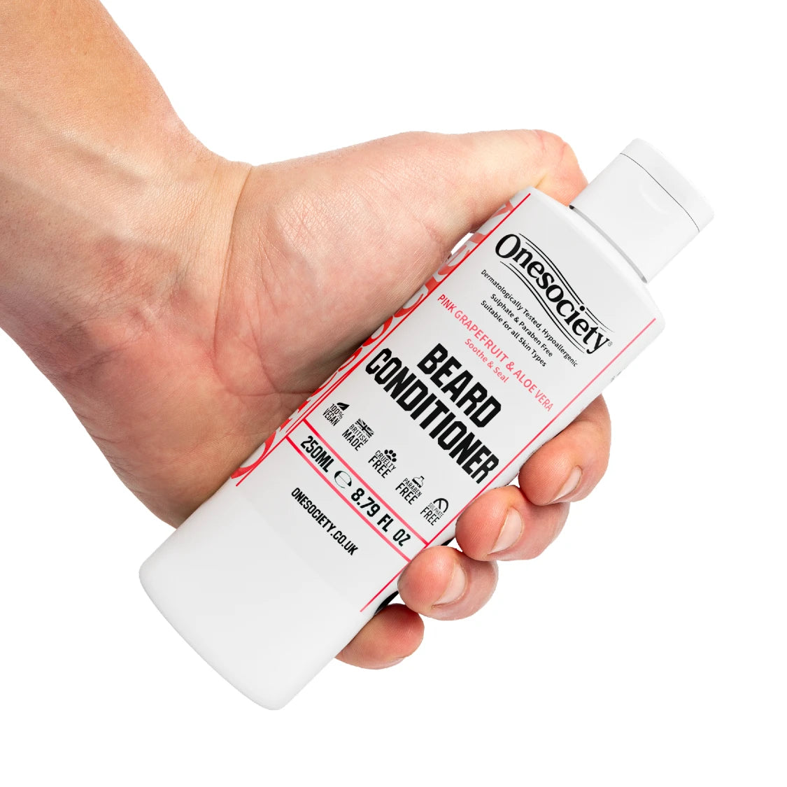 Hand holding a bottle of Pink Grapefruit Onesociety beard conditioner against a white background