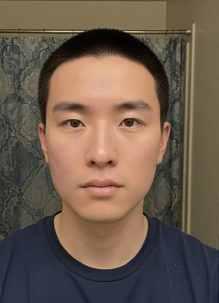 Man wearing a dark blue shirt in front of a shower curtain