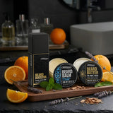 Onesociety beard care products including balm, cream, and booster on a wooden tray with oranges and lavender.