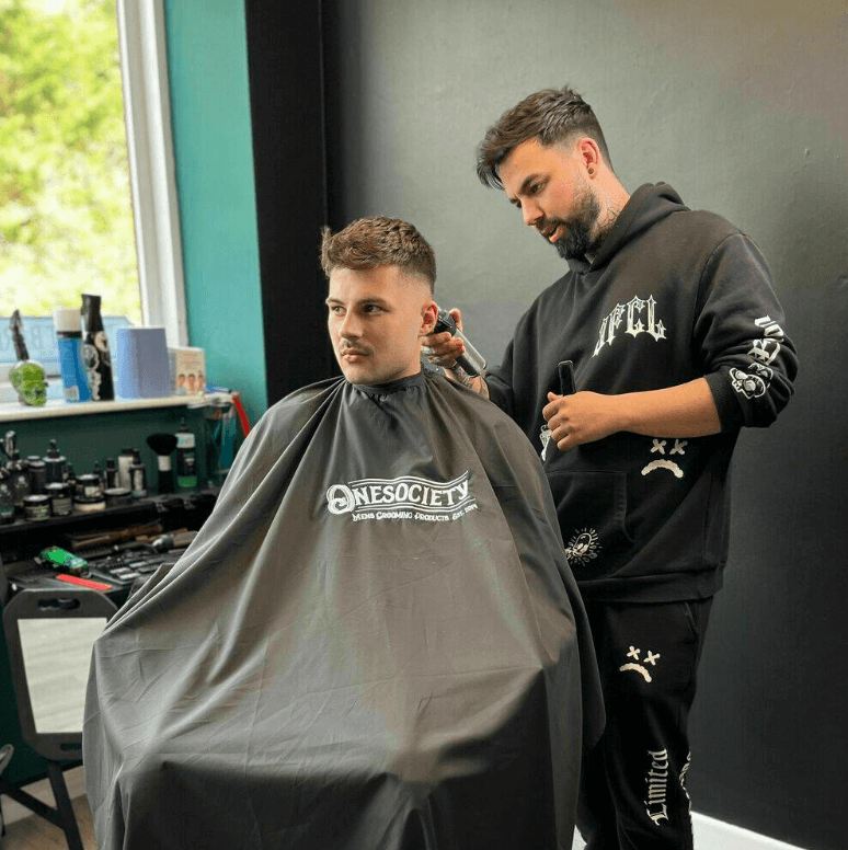 Paul cutting hair for onesociety men's grooming products.