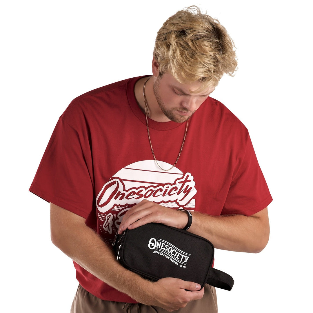 Man wearing One Soceity Red T-Shirt, holding one society black bag