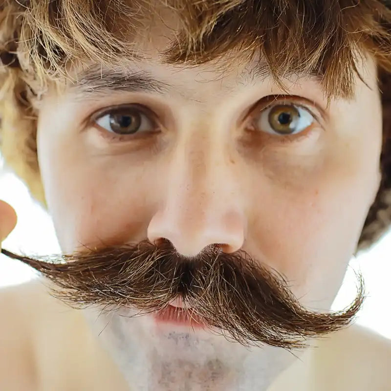 Close-up of a man with a bushy mustache and beard.