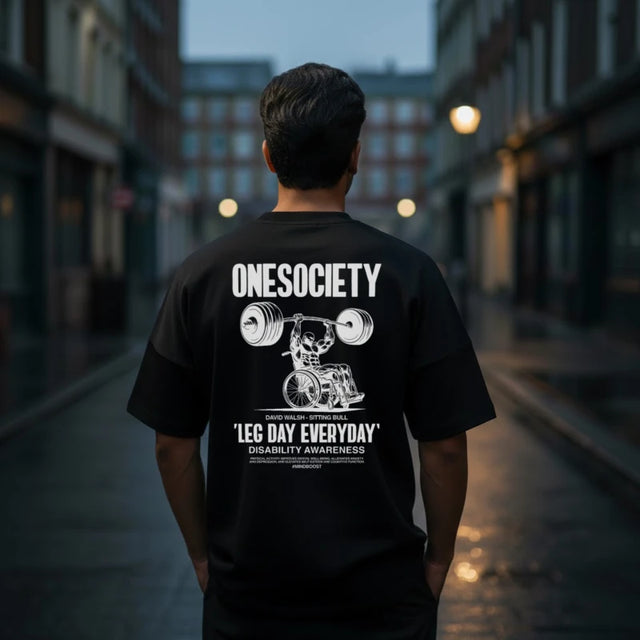 Person wearing a black t-shirt with 'ONESOCIETY' design and text on a city street.