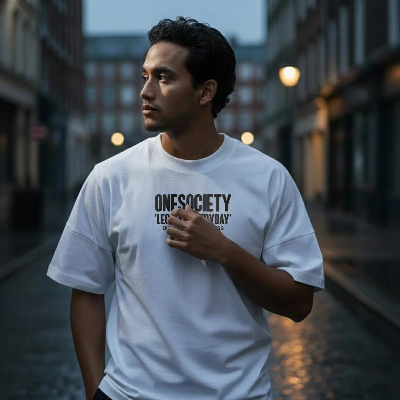Man wearing a white t-shirt with text on a city street