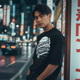 Man standing on a city street at night with neon signs in the background