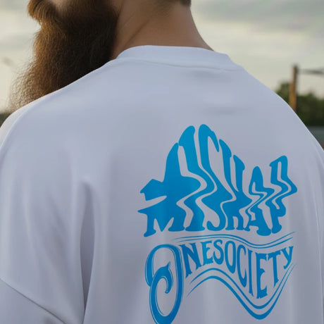 Person wearing a white shirt with blue 'Onesociety' logo on the back, outdoors.