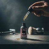 Sweet rum and lime beard oil by one society with lid off and shaver in the background