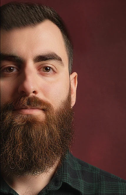 Man with a beard and mustache against a red background