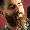 Person with a beard speaking into a microphone