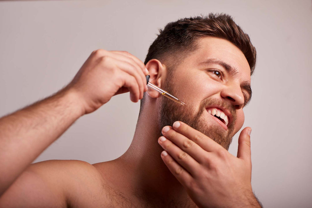Beard oil how to use man applying beard growth oil on to chin
